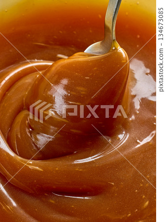 freshly cooked caramel sauce background freshly cooked caramel sauce background 134673085