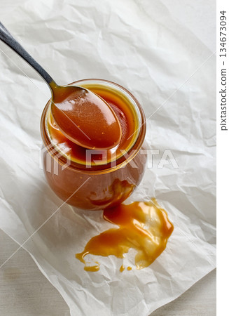 freshly cooked homemade caramel sauce in jar 134673094