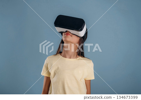 Virtual reality headset. Young girl is against background 134673399