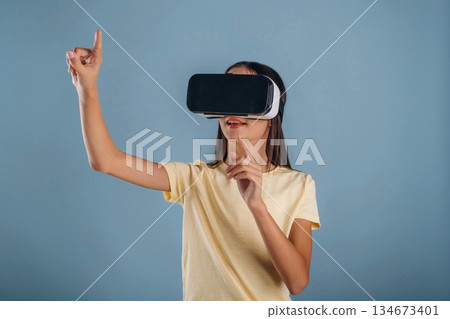 Virtual reality headset. Young girl is against background 134673401
