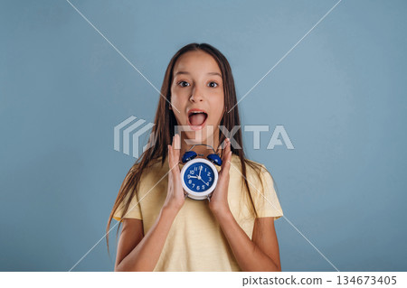 Time is running out, surprised, shocked, with clock. Young girl is against background Time is running out, surprised, shocked, with clock. Young girl is against background 134673405