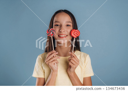 Sweet candies. Young girl is against background 134673436