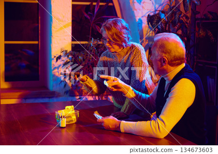 Elderly couple managing medication with voice assistant at home. Elderly couple managing medication with voice assistant at home. 134673603