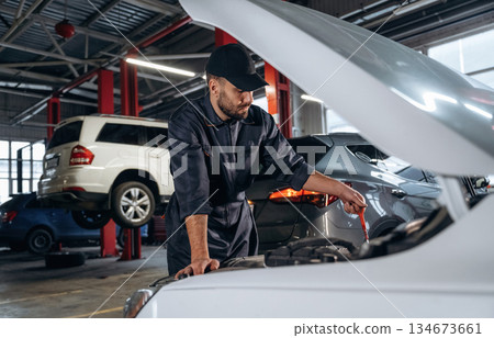 In the cap, busy. Mechanic working in a car service station 134673661