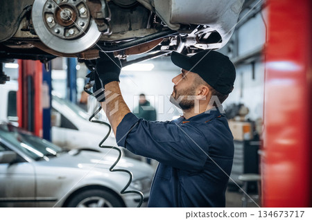 Professional equipment. Mechanic working in a car service station Professional equipment. Mechanic working in a car service station 134673717