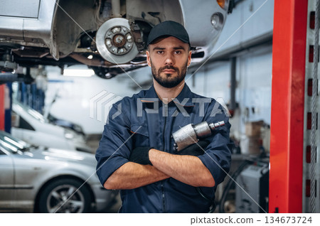 Special tool in hand. Mechanic working in a car service station 134673724