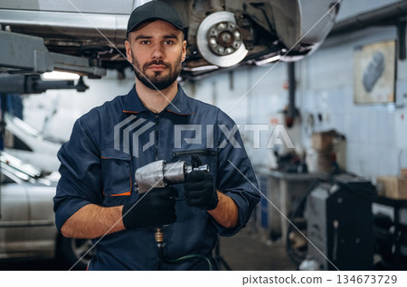 Professional equipment. Mechanic working in a car service station Professional equipment. Mechanic working in a car service station 134673729