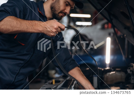 Cable installation. Mechanic working in a car service station Cable installation. Mechanic working in a car service station 134673765