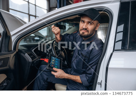Dislike, thumb down. Mechanic working in a car service station Dislike, thumb down. Mechanic working in a car service station 134673775