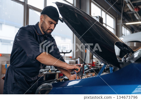 Service station, busy. Mechanic is working 134673796