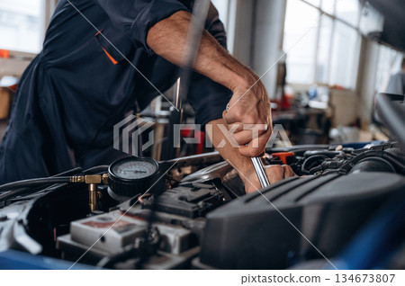 Opened hood. Close up view of mechanic in car service station Opened hood. Close up view of mechanic in car service station 134673807