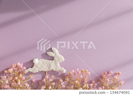 Easter Bunny Stick and Pastel Flowers on Purple Background Easter Bunny Stick and Pastel Flowers on Purple Background 134674091