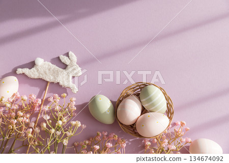 Easter Bunny Stick and Pastel Eggs with Flowers on Purple Background Easter Bunny Stick and Pastel Eggs with Flowers on Purple Background 134674092
