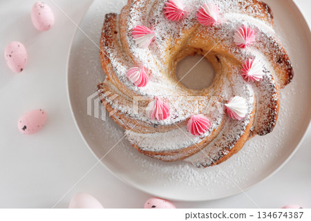 Traditional Easter cakes with icing decorated candies on white wooden table 134674387