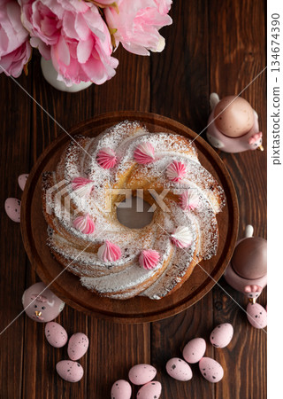Traditional Easter cakes with icing decorated candies on dark wooden table Traditional Easter cakes with icing decorated candies on dark wooden table 134674390
