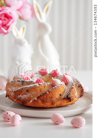 Traditional Easter cakes with icing decorated candies on white wooden table 134674393