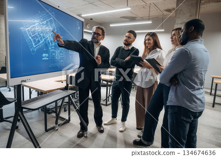 Building plan on screen. Group of office workers are indoors together 134674636