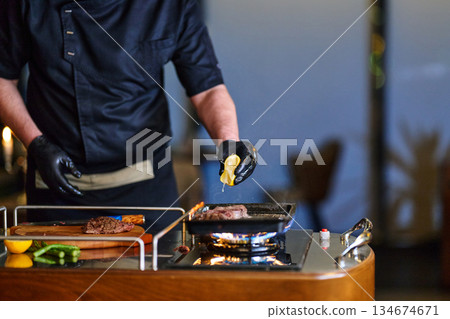 Chef preparing fresh meat with lemon during iftar meal in restaurant space for Ramadan gathering Chef preparing fresh meat with lemon during iftar meal in restaurant space for Ramadan gathering 134674671