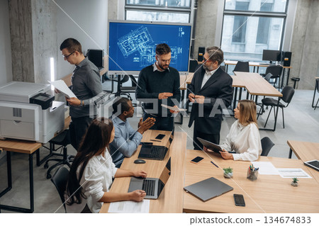 New project, team of people is busy. Group of office workers are indoors together 134674833