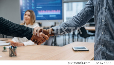 Deal, doing handshake. Group of office workers are indoors together Deal, doing handshake. Group of office workers are indoors together 134674888