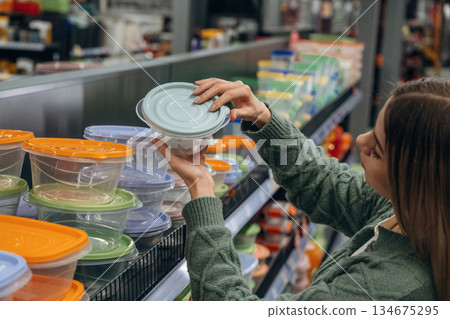 Food trays. Woman is in the hardware store, shopping conception Food trays. Woman is in the hardware store, shopping conception 134675295