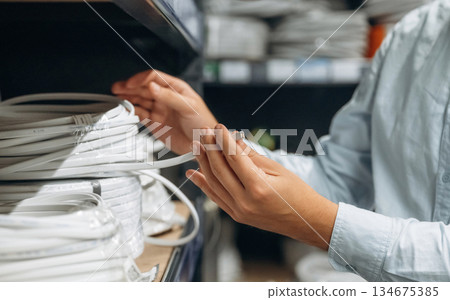 Cables in hands. Detailed close up view of man's hand in the hardware store 134675385