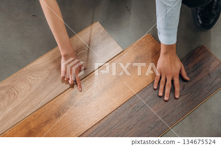 Choosing the parquet. Man and woman are in the hardware store Choosing the parquet. Man and woman are in the hardware store 134675524