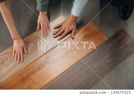 Choosing the parquet. Man and woman are in the hardware store Choosing the parquet. Man and woman are in the hardware store 134675525