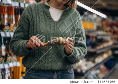 Brand new paintbrush. Close up view of woman that is in the hardware store Brand new paintbrush. Close up view of woman that is in the hardware store 134675566