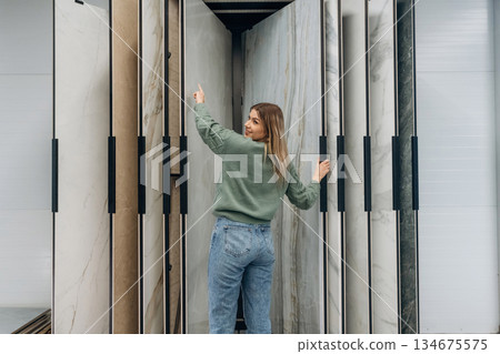 Searching for perfect plate for kitchen. Woman is in the hardware store, shopping conception Searching for perfect plate for kitchen. Woman is in the hardware store, shopping conception 134675575