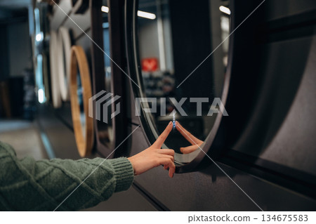 Mirror with touch screen. Close up view of woman that is in the hardware store 134675583