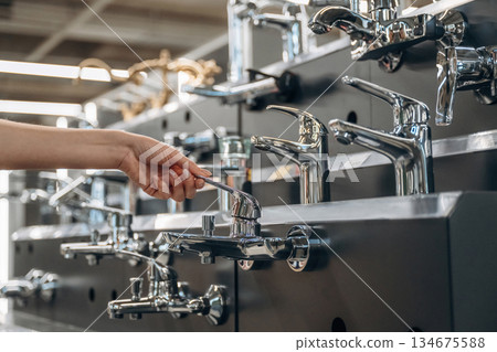 Bathroom tap. Close up view of woman that is in the hardware store Bathroom tap. Close up view of woman that is in the hardware store 134675588