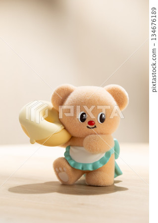 Backlit ButterBear Toy Holding a Large Donut on Fabric Surface 134676189
