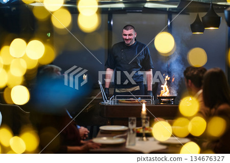 Chef prepares meal for family iftar gathering during Ramadan in warm restaurant setting with joyful atmosphere 134676327