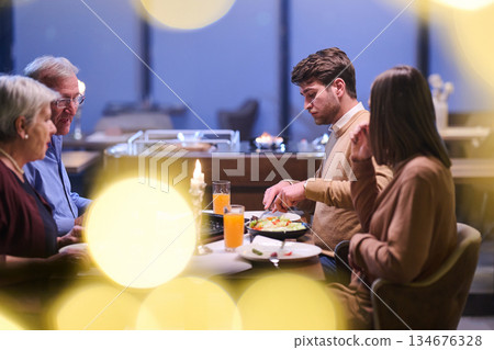 Family gathers for iftar during Ramadan sharing food and stories in a warm setting with yellow lights Family gathers for iftar during Ramadan sharing food and stories in a warm setting with yellow lights 134676328