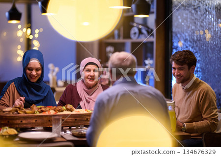 Family gathers for iftar during Ramadan in a warm restaurant setting Family gathers for iftar during Ramadan in a warm restaurant setting 134676329