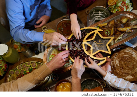 Families gather for iftar celebration during Ramadan with traditional dishes and shared moments of joy and connection 134676331