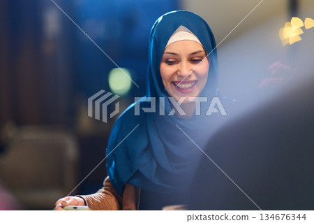 Woman smiling during iftar gathering with family reflecting Ramadan traditions and community spirit in cozy dining setting Woman smiling during iftar gathering with family reflecting Ramadan traditions and community spirit in cozy dining setting 134676344