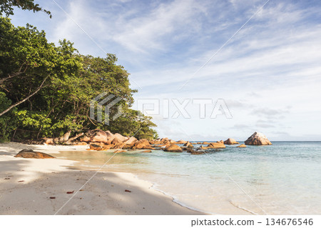 A tranquil tropical beach scene featuring clear shallow water and soft white sand A tranquil tropical beach scene featuring clear shallow water and soft white sand 134676546