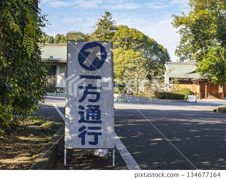 藍天綠樹環繞著一塊單行道標誌牌 134677164