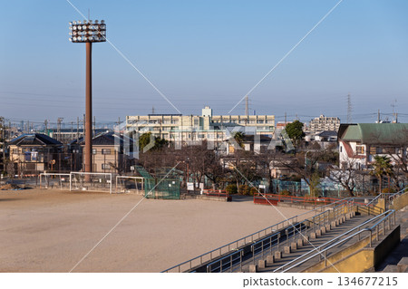 A view of the designated evacuation shelter, an elementary school, and a soccer goal from the stands at Matsubara Civic Sports Park 134677215