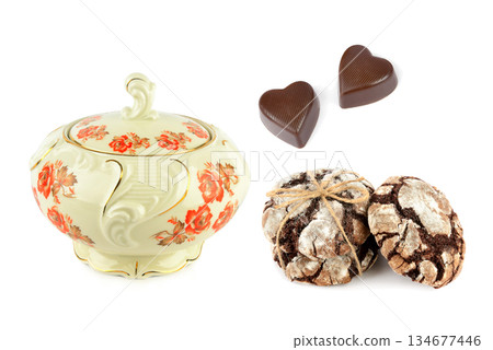 Vintage porcelain sugar bowl with heart-shaped chocolates and brownies isolated on white. 134677446