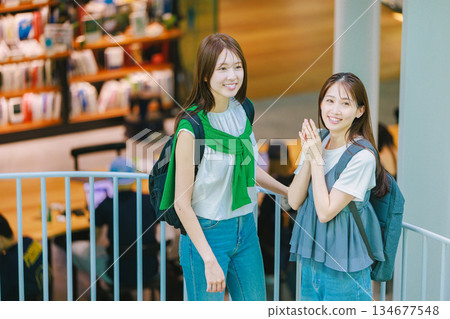 一名女大學生與朋友一起爬校園樓梯 134677548