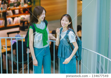 一名女大學生與朋友一起爬校園樓梯 一名女大學生與朋友一起爬校園樓梯 134677549