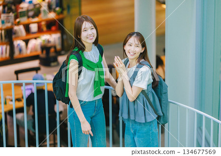 一名女大學生與朋友一起爬校園樓梯 134677569