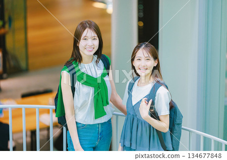 一名女大學生與朋友一起爬校園樓梯 134677848