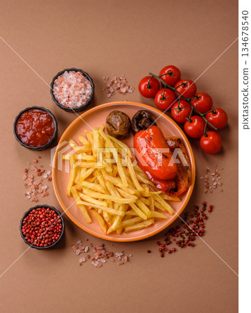 French fries cooked in oil, crispy golden chips, unhealthy food. French fries as a background French fries cooked in oil, crispy golden chips, unhealthy food. French fries as a background 134678540