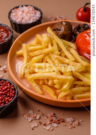 French fries cooked in oil, crispy golden chips, unhealthy food. French fries as a background French fries cooked in oil, crispy golden chips, unhealthy food. French fries as a background 134678545