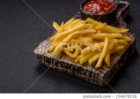 French fries cooked in oil, crispy golden chips, unhealthy food. French fries as a background French fries cooked in oil, crispy golden chips, unhealthy food. French fries as a background 134678558