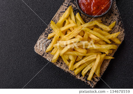 French fries cooked in oil, crispy golden chips, unhealthy food. French fries as a background French fries cooked in oil, crispy golden chips, unhealthy food. French fries as a background 134678559